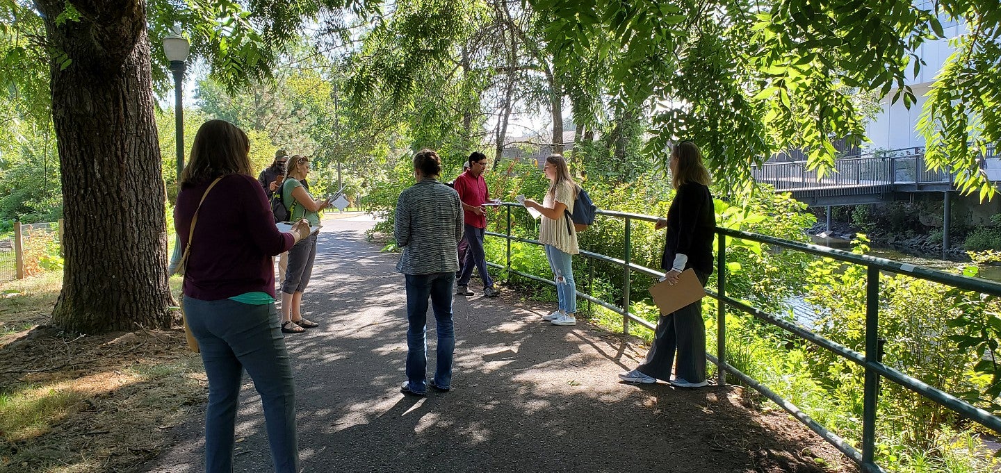 People attend a UO Sustainable Campus tour with a stop near the Urban Farm and Knight Campus.