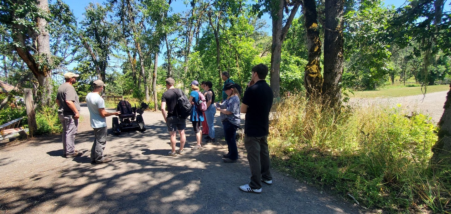 2024 Sustainability Fellows learn about an all-terrain, all-access wheelchair available to check out at Mt. Pisgah Arboretum