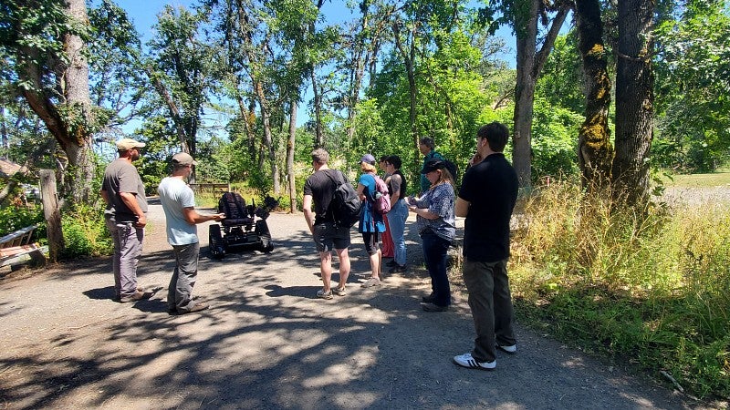 2024 Sustainability Fellows learn about an all-terrain, all-access wheelchair available to check out at Mt. Pisgah Arboretum