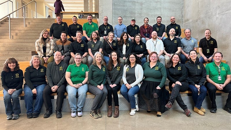 Group photo of design and construction staff sitting on steps in the EMU.