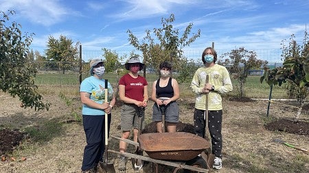 Masked students in the Environmental Leaders ARC pause from their farm work for a picture.