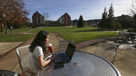 A student enjoys a fruit smoothy in the sunshine behind the Law School on Friday, Jan. 22, 2016, on the University of Oregon campus in Eugene, Oregon.